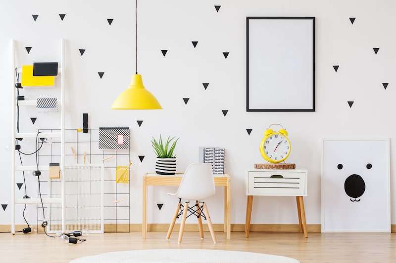 Mockup of poster on the wall in cozy kindergarten with yellow lamp and clock on cabinet next to desk