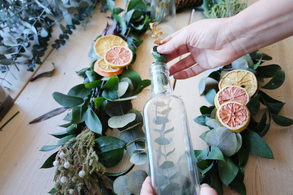 Use glass bottles to focus the attention of the Christmas centerpiece